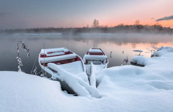 Лодки зимой на ледяном озере — стоковое фото