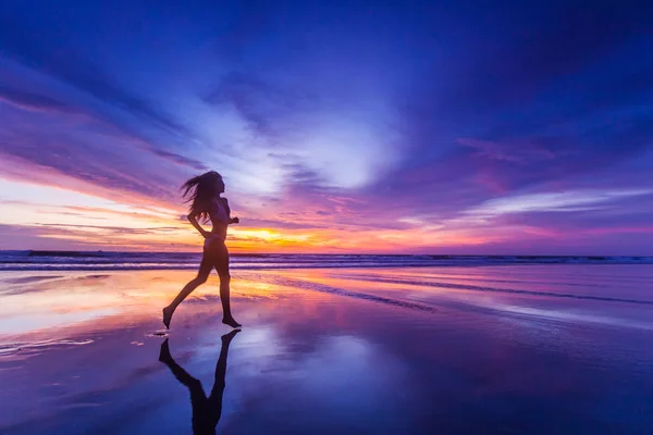 비키니를 아름다운스 포티걸 일몰에 해변을 달리고 — 스톡 사진
