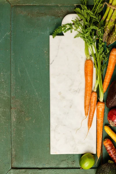 Assortment of raw organic fruits and vegetables: eggplants, onions, berries, carrots, grapes, cabbage, avocado, plums over rustic background, gluten free, allergy-friendly, clean eating or raw diet. Top view with space. Food frame — Stock Image Assortment Raw Organic Fruits Vegetables Eggplants Onions Berries Carrots Grapes Stock Photo