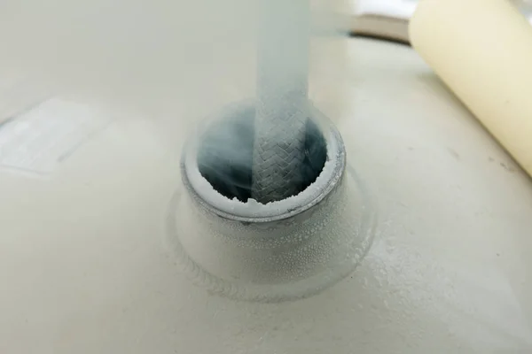 Close up of container with liquid nitrogen,Cold metal pipe smoking from transferring liquid nitrogen