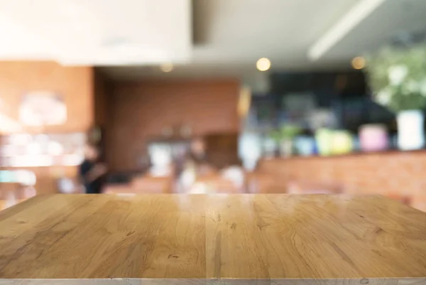 コーヒーショップの抽象的なぼやけた背景の前に空の木製のテーブル 製品のモックアップを表示するために使用できます — ストック写真