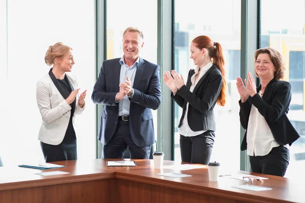 Gente Negocios Aplaudiendo Sonriendo Oficina Pie Alrededor Mesa Reuniones —  Fotos de Stock