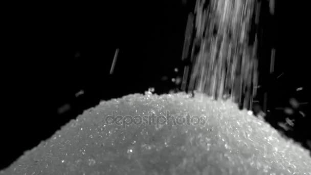 Hromadu cukru na černém pozadí natáčení s vysokorychlostní kamerou zblízka — Stock video