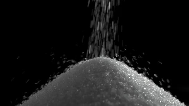 Haufen Zucker auf schwarzem Hintergrund mit Hochgeschwindigkeitskamera — Stockvideo