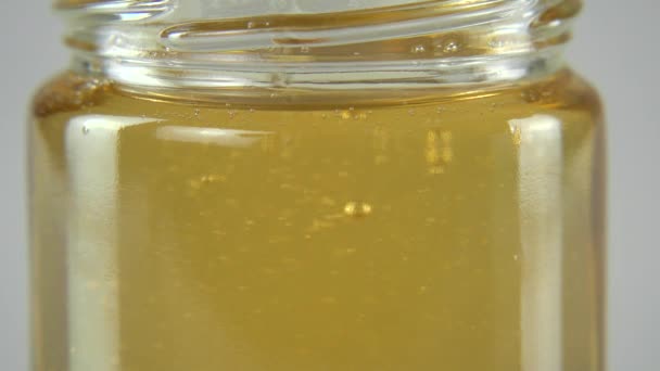 Sumerge la cuchara de madera en la miel — Vídeo de stock