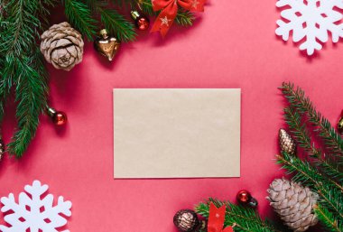 Üst manzara, ladin yeşil dalları ve yeni yıl oyuncakları ve pembe arka planda fiyonklar.