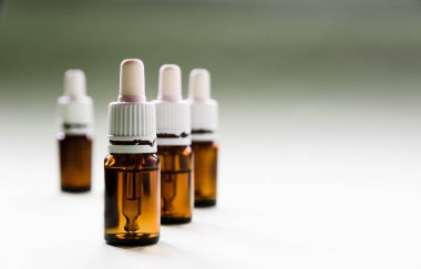 Kozmetoloji, cilt bakımı, içinde pipetler ve ışık arkaplan üzerindeki hyaluronik asit olan bir dizi cam şişe.