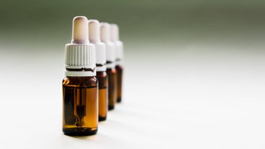 Kozmetoloji, cilt bakımı, içinde pipetler ve ışık arkaplan üzerindeki hyaluronik asit olan bir dizi cam şişe.