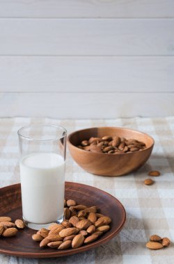 Sağlıklı gıda kavramı, badem ve masada duran bir bardak süt.
