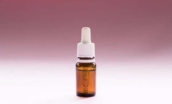 Cosmetología, botellas de vidrio con pipetas y cosméticos sobre un fondo rosa —  Fotos de Stock