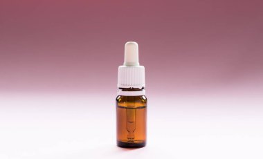 Kozmetik, pipetli cam şişeler ve pembe arka planda kozmetik.