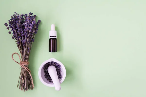 Fondo spa con flores violetas y frasco de vidrio con aceite esencial . — Foto de Stock