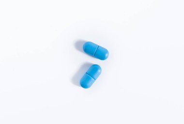 İlaç endüstrisi konsepti, beyaz arka planda mavi haplar.