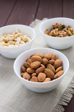 Tahta bir masada badem, ceviz ve fındık.