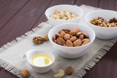Tahta bir masada yağlı badem, ceviz ve fındık.
