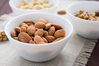 Tahta bir masada diyet yemek kavramı, badem, ceviz ve fındık.