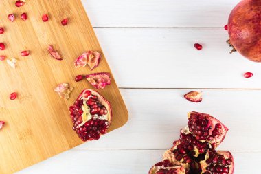 Beyaz ahşap bir masada olgun kırmızı nar.