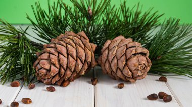 Çam fıstığı ahşap masa üzerinde kaşık ve çam fıstığı koni. Organik gıda.