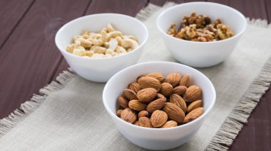 Tahta bir masada diyet yemek kavramı, badem, ceviz ve fındık.