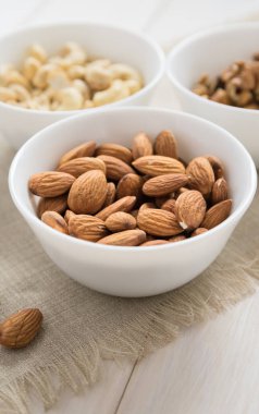 Tahta bir masada diyet yemek kavramı, badem, ceviz ve fındık.
