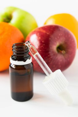 Kozmetik konsept, meyve arka planında alfa hidroksi asitli serumlu cam şişe.