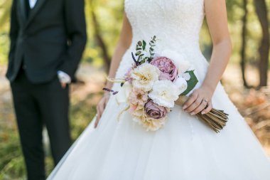 Beyaz elbiseli gelin, arkasında duran damat ve... 