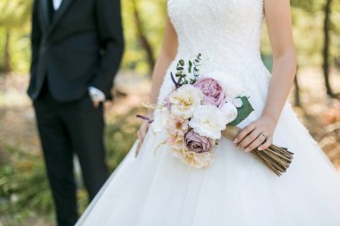 Beyaz elbiseli gelin, arkasında duran damat ve... 