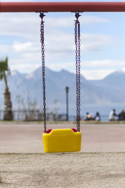 Empty swing with yellow and red colors — 스톡 사진