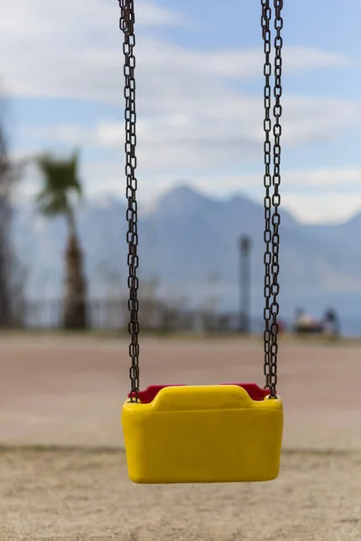 Empty swing with yellow and red colors — 스톡 사진