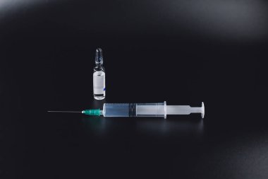 Renkli zeminde şırınga ve ilaç şişesi metali