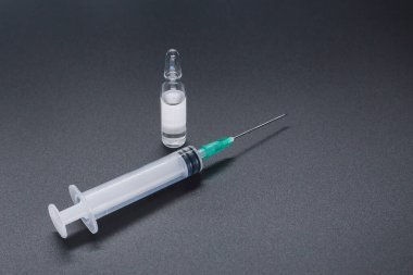 Renkli zeminde şırınga ve ilaç şişesi metali