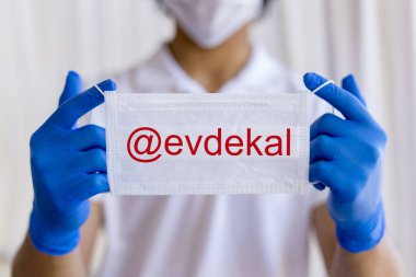 Maske ve eldiven takan korunan bir genç.