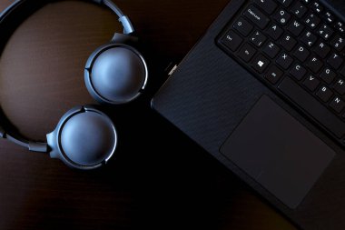 Laptop, telefon, dolma kalem ve cam eski ahşap masada.