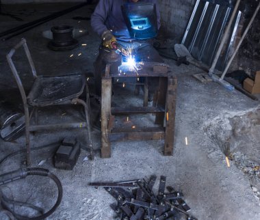 Atölyede demir kaynaklama yapan işçi.