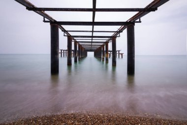 Demir iskele altında uzun pozlu deniz fotoğrafı