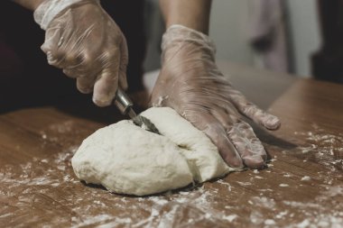 Türkiye 'de masada plastik eldivenle hamur yapan bir kadının elleri