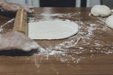 Türkiye 'de masada plastik eldivenle hamur yapan bir kadının elleri