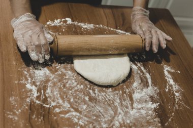 Türkiye 'de masada plastik eldivenle hamur yapan bir kadının elleri