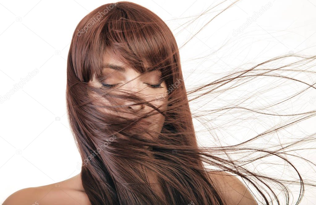 Beautiful young woman with healthy long hair waving aside