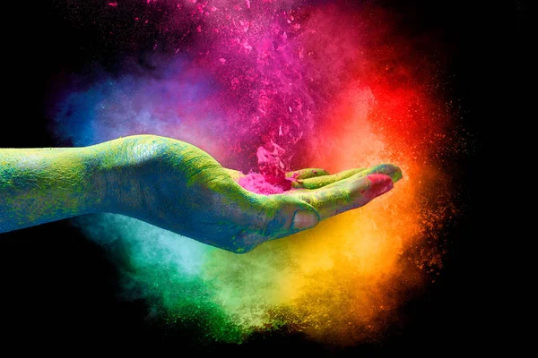Sihirli gökkuşağı renkli toz bir elden patlıyor. Holi Festiva