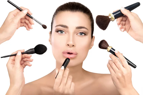 Beauty model with makeup brushes in make up process