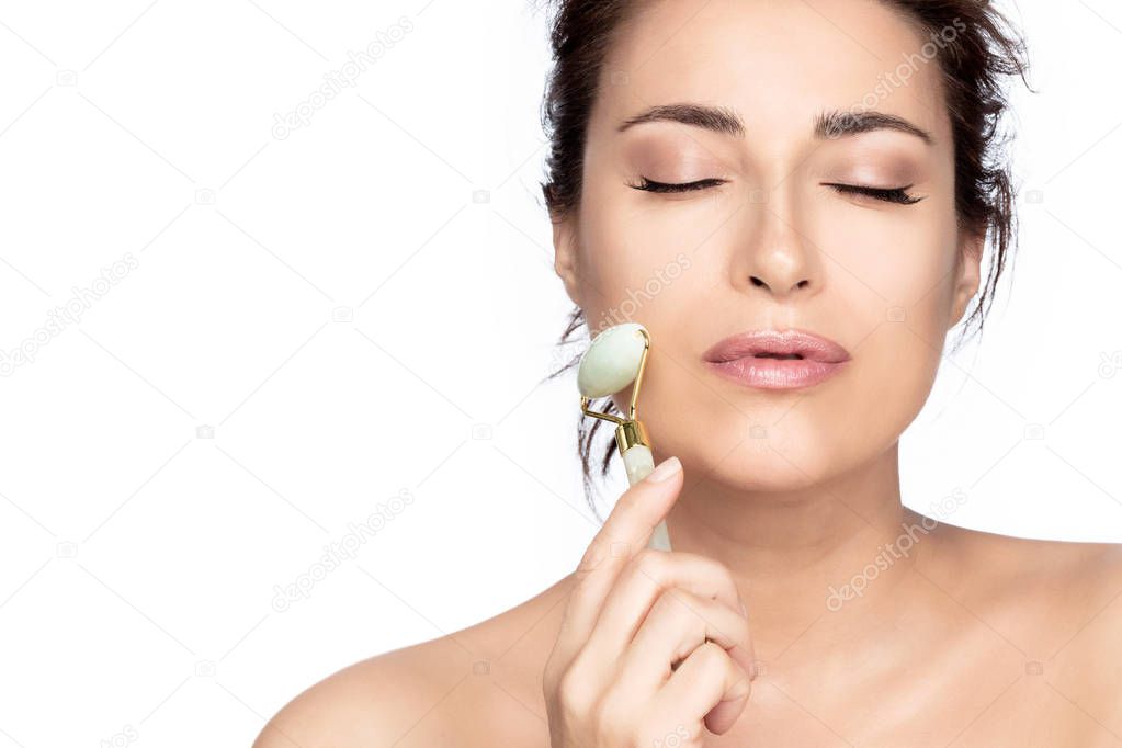 Beautiful model woman with healthy fresh clean skin using a jade