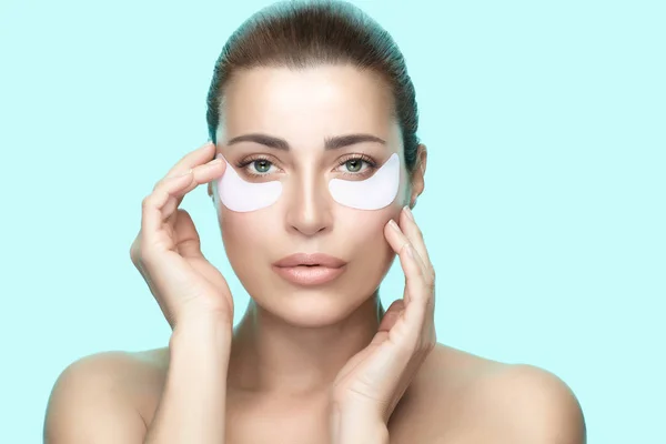 Beauty and eye skin care concept. Young woman using pads under e — Stock Photo, Image
