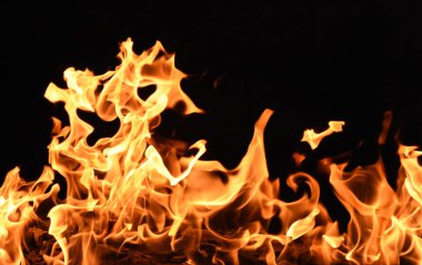 Siyah arka planda sarı ve turuncu alevlerle ateş