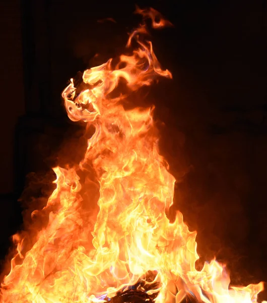 Siyah arka planda sarı ve turuncu alevlerle ateş