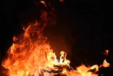 Siyah arka planda sarı ve turuncu alevlerle ateş