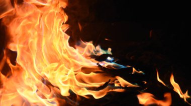 Siyah arka planda sarı ve turuncu alevlerle ateş