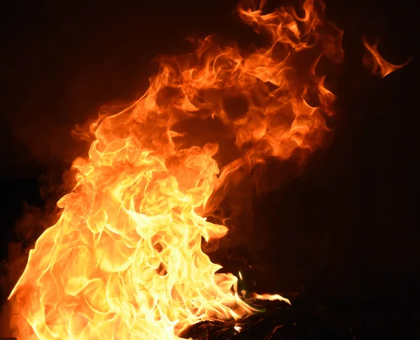 Siyah arka planda sarı ve turuncu alevlerle ateş