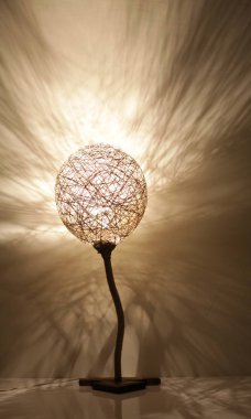 Duvarında gölgeler olan el yapımı ahşap ve halat lambası.