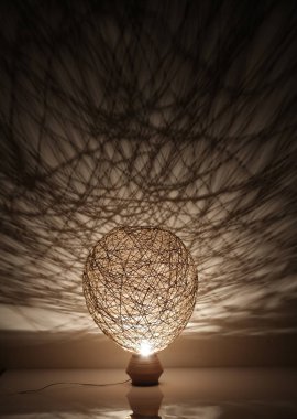 Duvarında gölgeler olan el yapımı ahşap ve halat lambası.